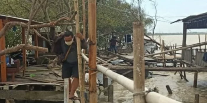 Seorang warga tengah berjalan di antara rumah warga di Desa Bedono, Kecamatam Sayung, Kabupaten Demak, Jawa Tengah, yang porak-poranda akibat terjangan ombak dan angin kencang, Selasa (8/12/2020). (ANTARA/HO-Dok.)